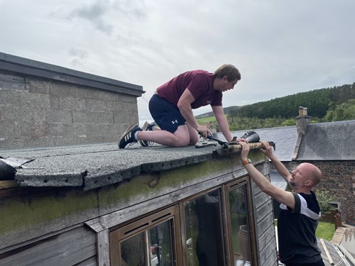 Team member fixing shed roof