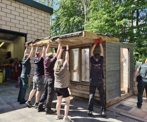 Team lifting shed roof into place